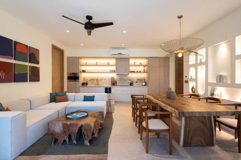 This is an image of a room at the Silvestre hotel showing a sofa, kitchen area and dining table