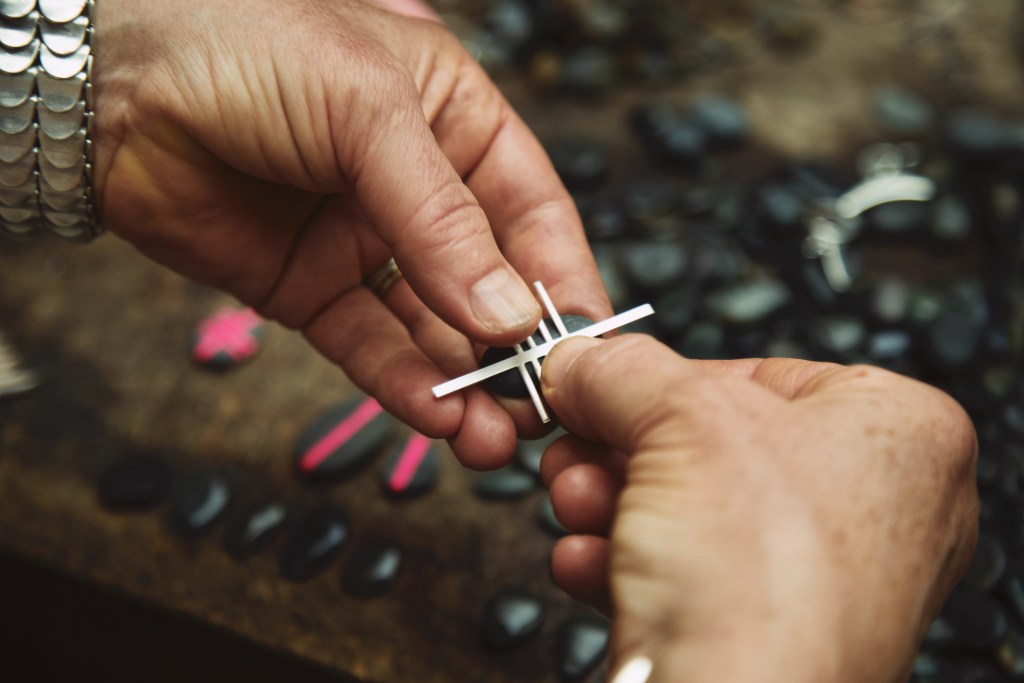 wrapping strips of silver around a beach stone