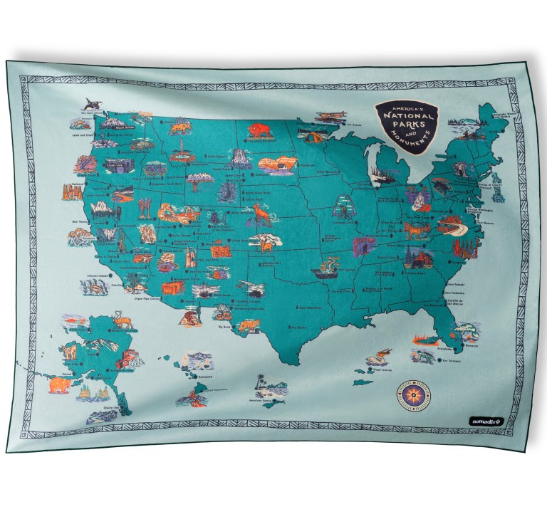 A colroful map of the US featuring its national parks on a large towel / blanket