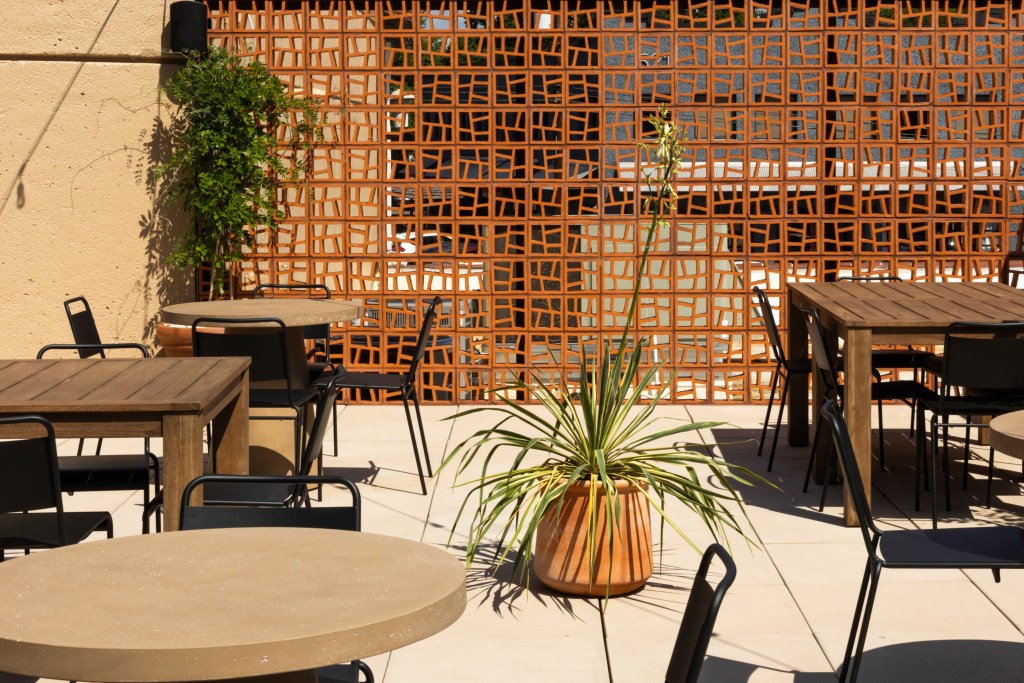 Tables, chairs and plants on the patio at the Coral Club