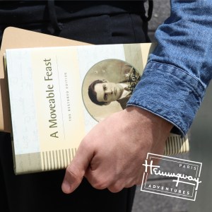A man holds a book by Ernest Hemingway