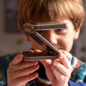 A child holds the Aurzen Zip projector