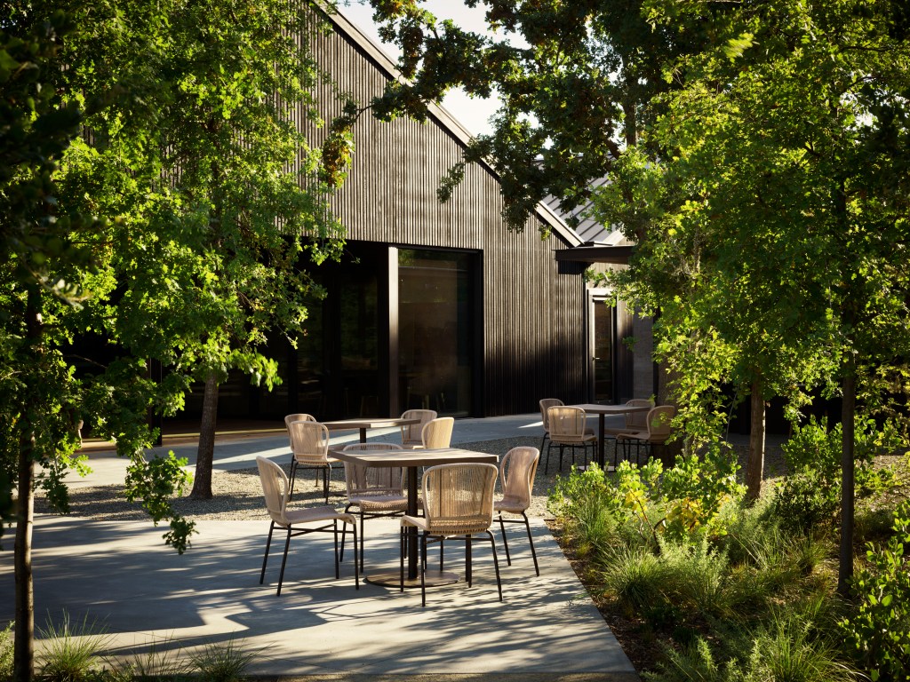 exterior of a modern building with outdoor seating and lush foliage