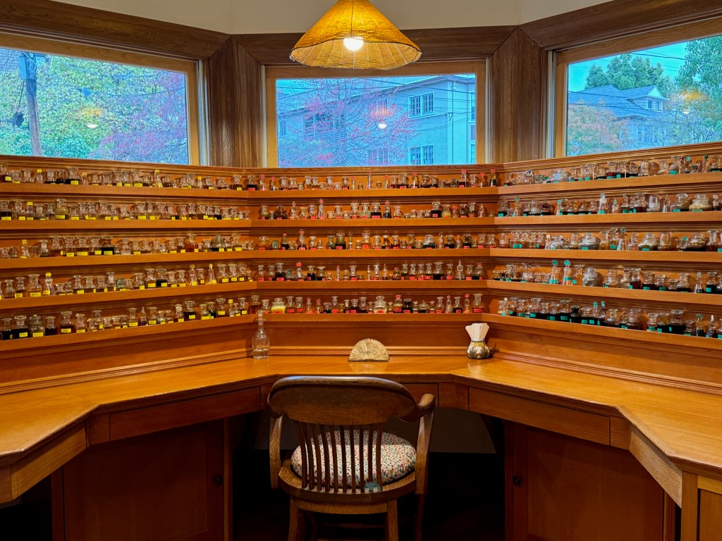 Large wrap-around desk with five rows of shelves holding small bottles