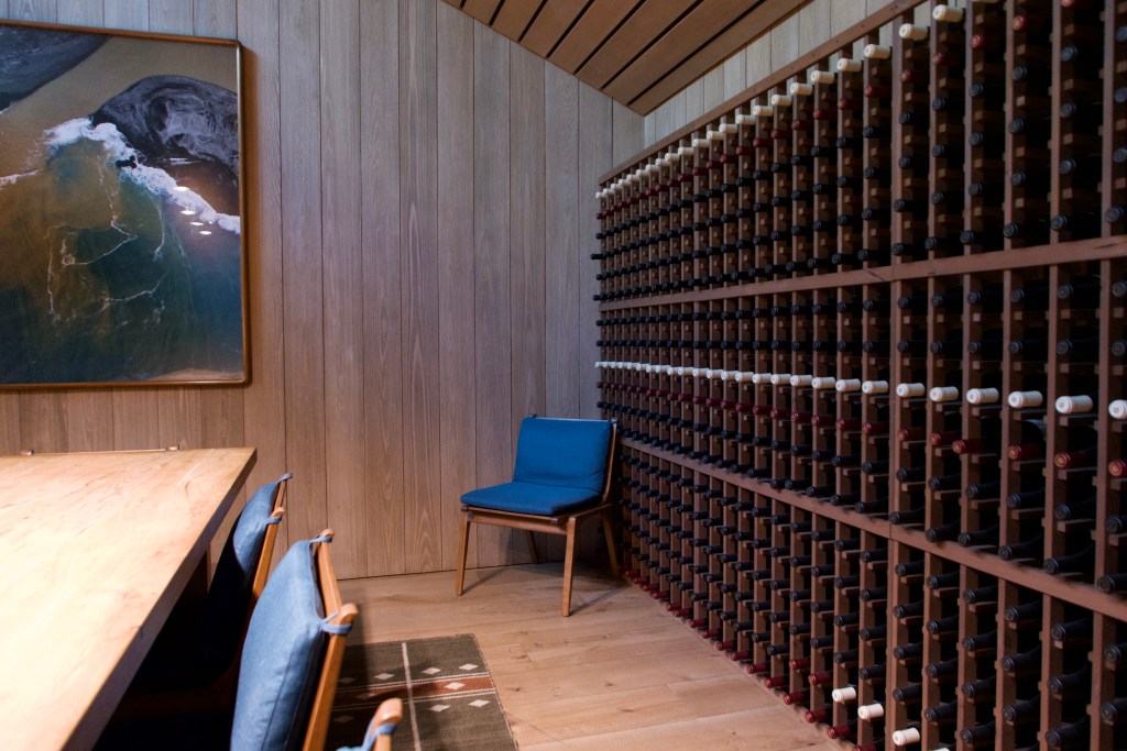 wine cellar with wall of bottles and table with chairs
