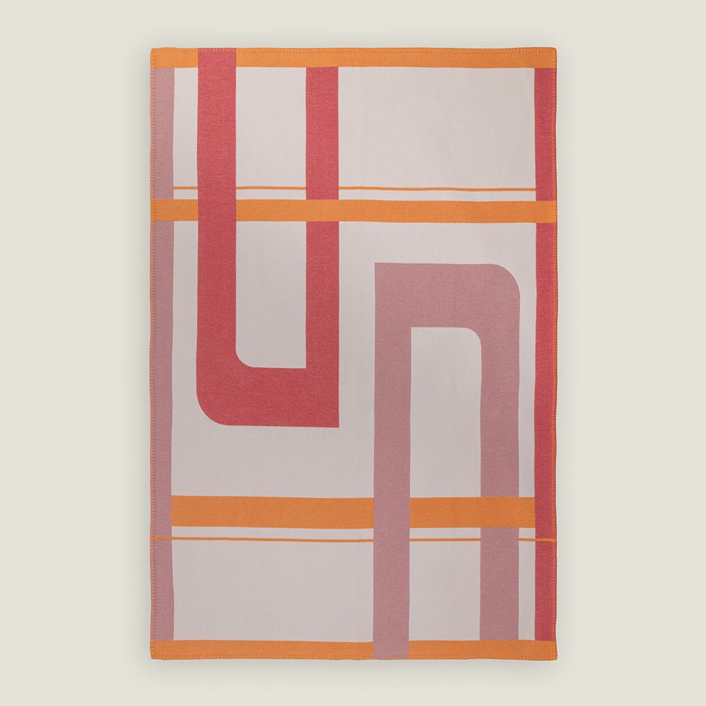 A full image of Range Rover's 90% wool, 10% cashmere blanket in a cream, orange and red graphic pattern