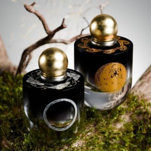 two perfume bottles on a mossy branch