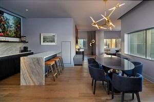 The dining area of the W Austin's Penthouse II suite features a large oval table, seated bar, kitchen and more