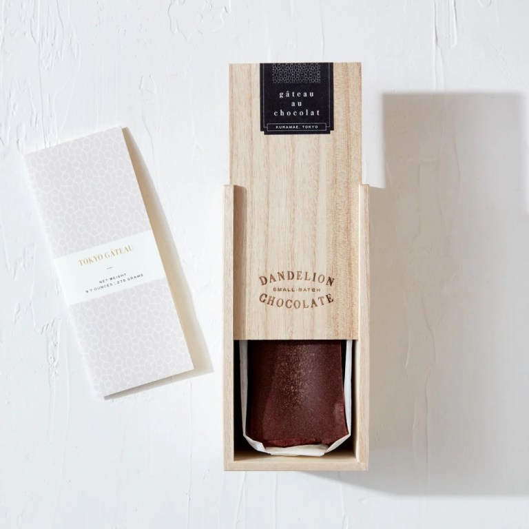A rectangular wood box slides open to reveal a chocolate cake
