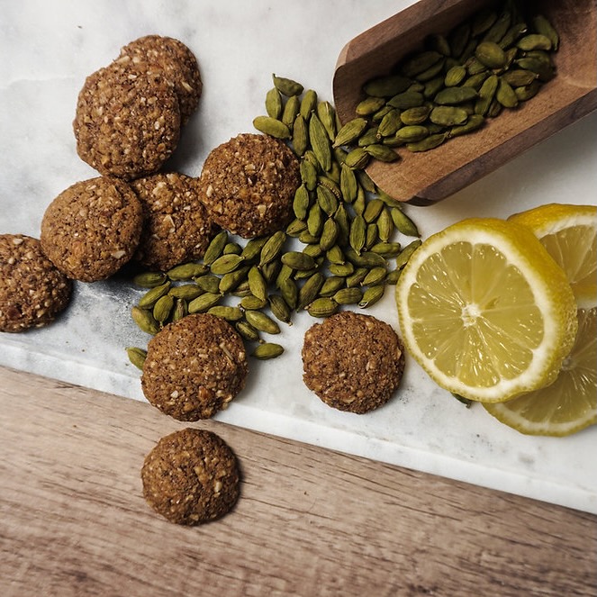 Cardomom pods, lemon slices and Krik's NOT JUST A COOKIE Lemon Cardomom cookies on a table