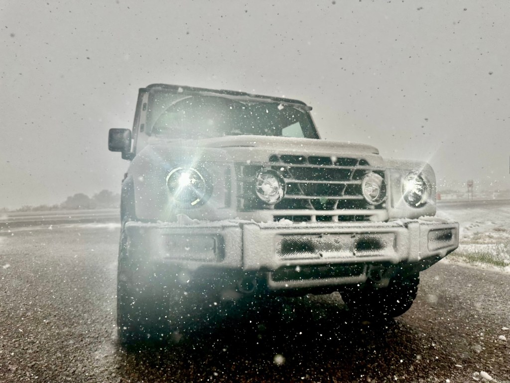An Ineos Grenadier in New Mexico facing forward in snowy conditions