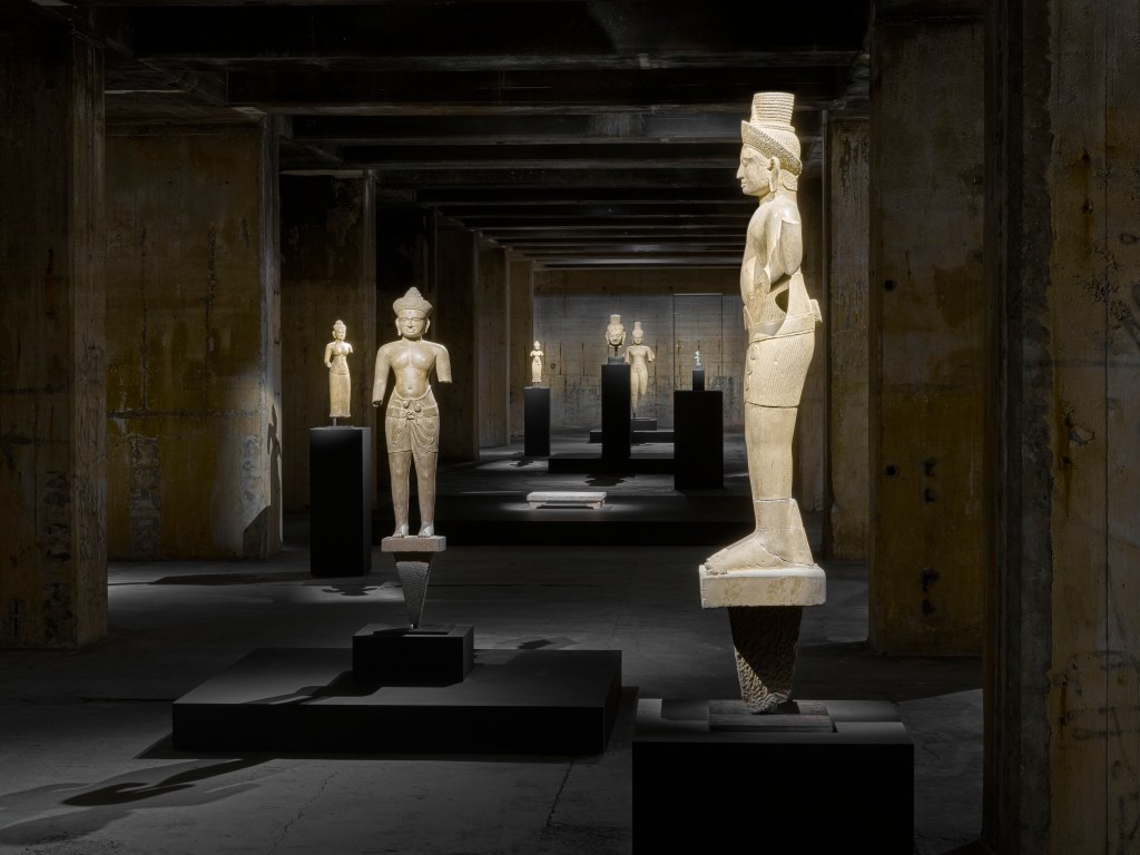 A collection of Far Eastern antiquities in a dark gallery room at the Feuerle Collection.