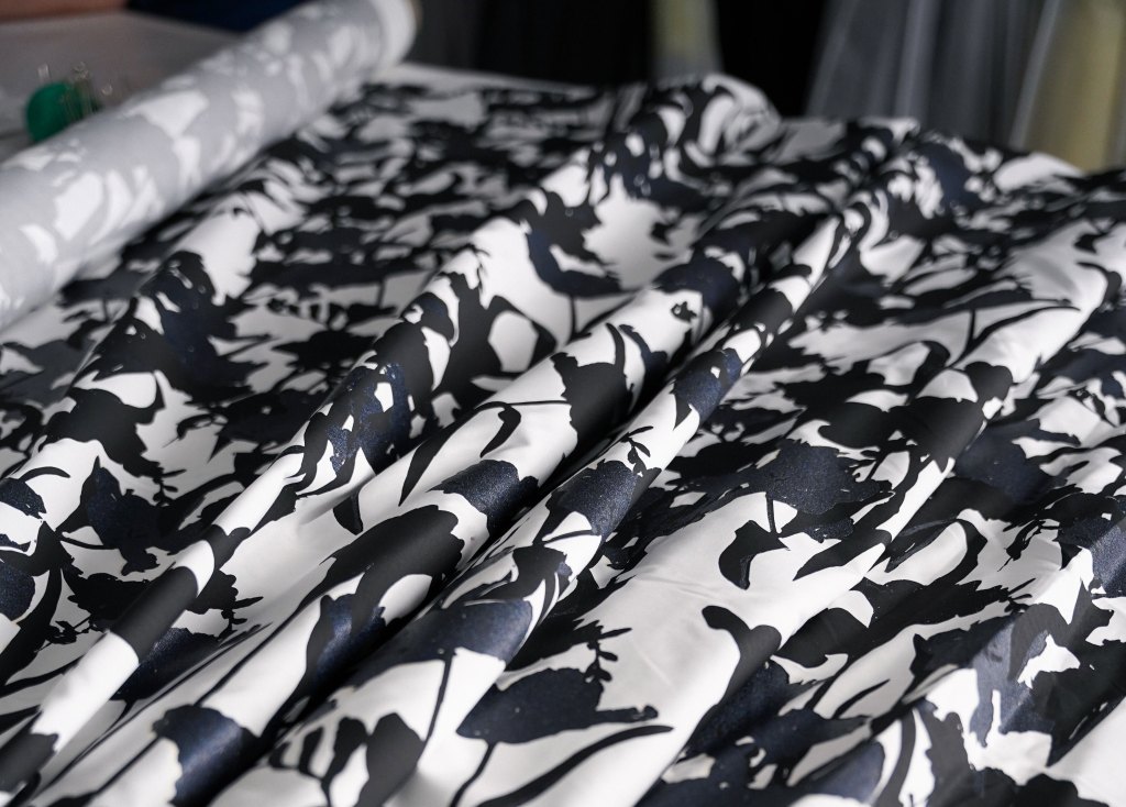 A closeup of a blue floral printed fabric with a white background