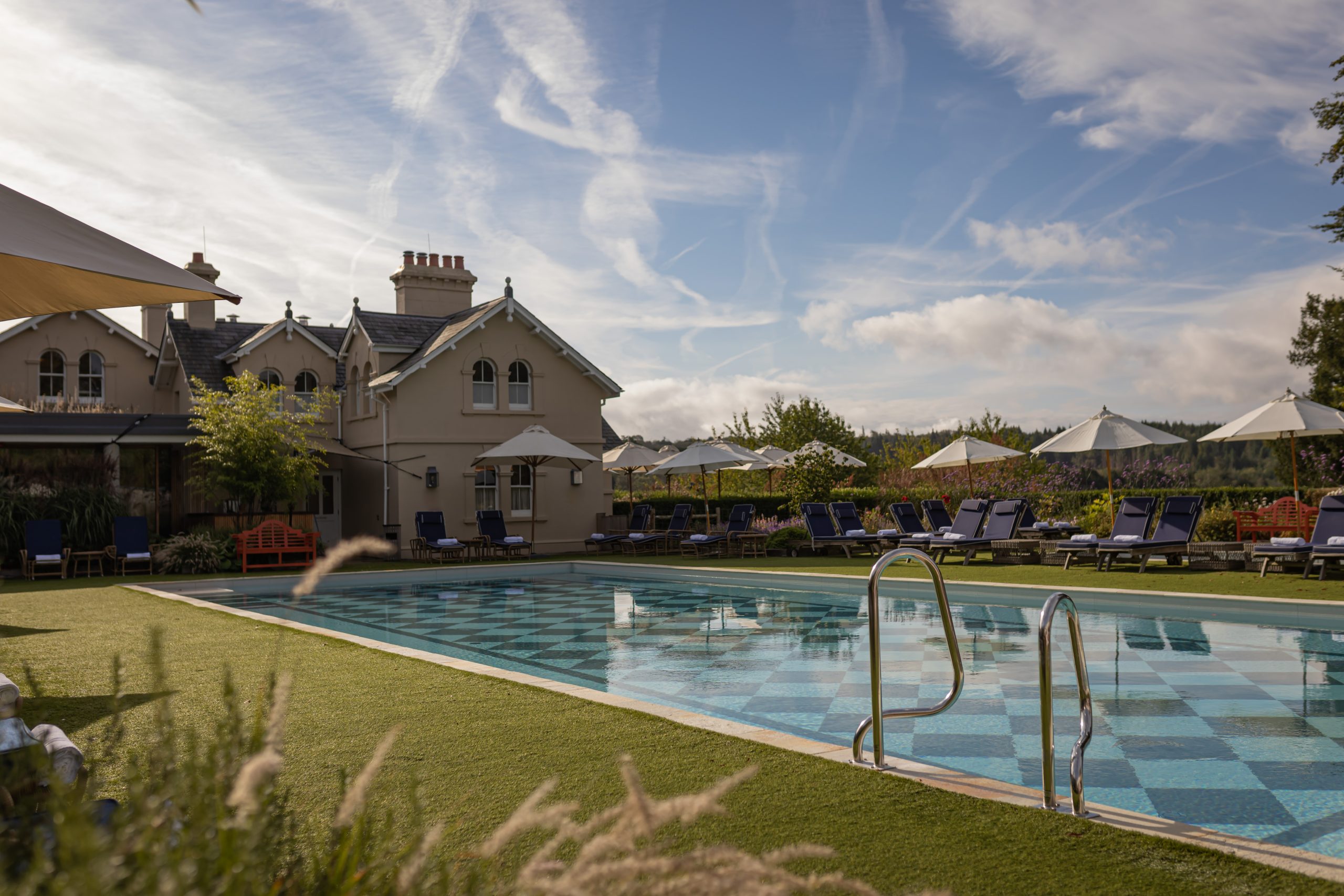 A swimming pool with the historic Beaverbrook. building in the background.