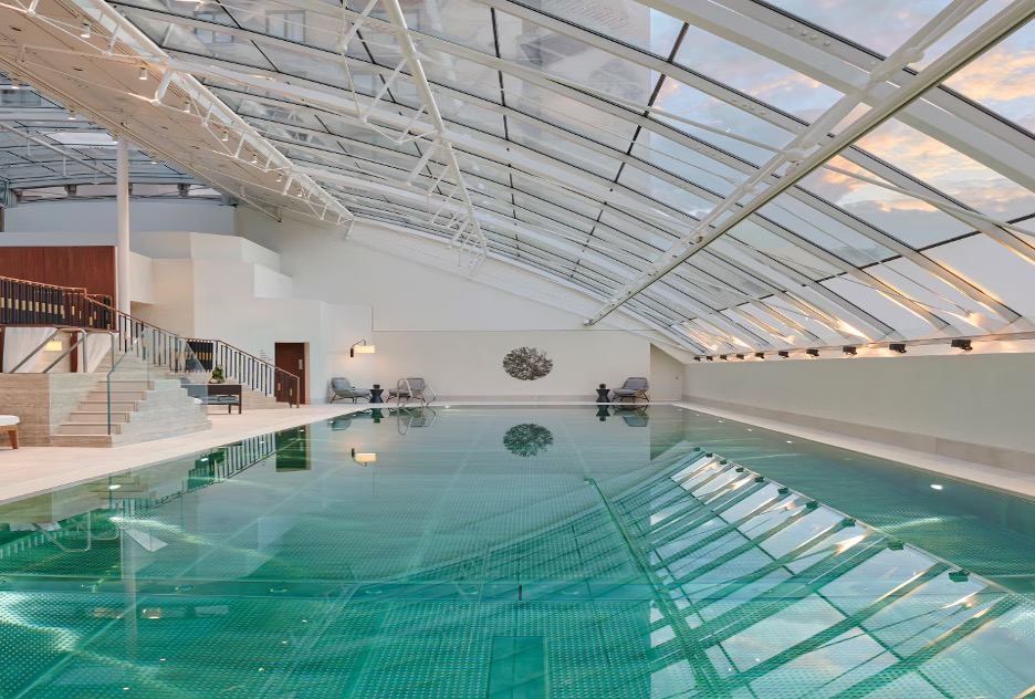 A swimming pool with an arched glass ceiling.