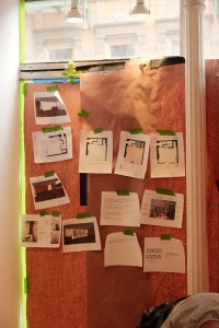 floor plans and inspiration images taped to a wall in a store under construction