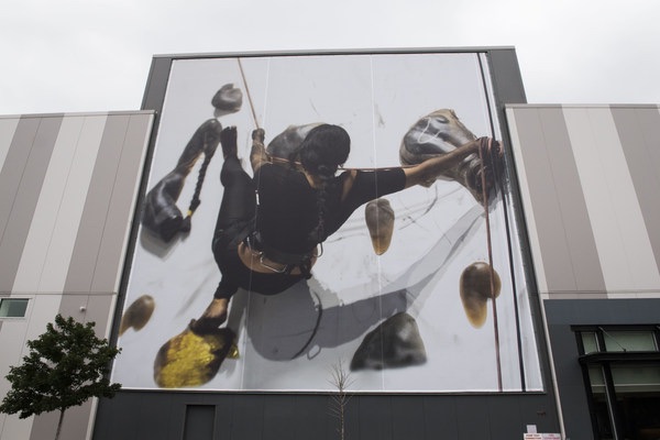 A large-scale image of Baseera Khan performing their multi-disciplinary work, Braidrage.