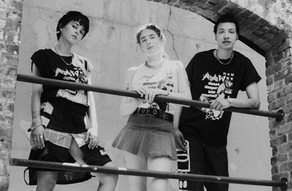 A group of three people standing on a ledge wearing Infinite Transition shirts.