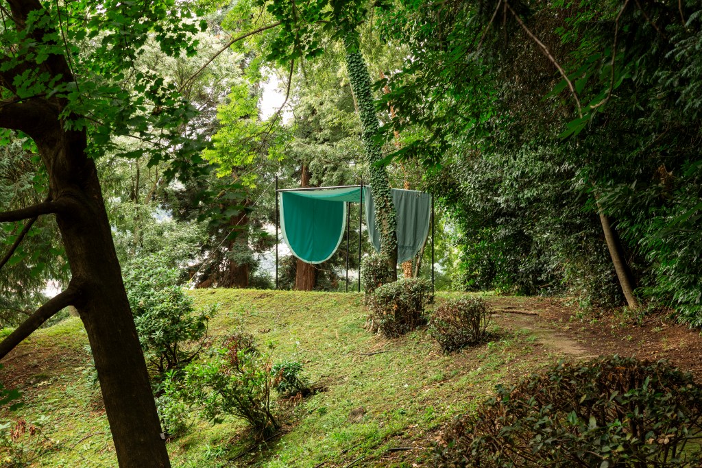 An outdoor tent by We Mediterranean, developed by Caterina Frongia, surrounded by trees.