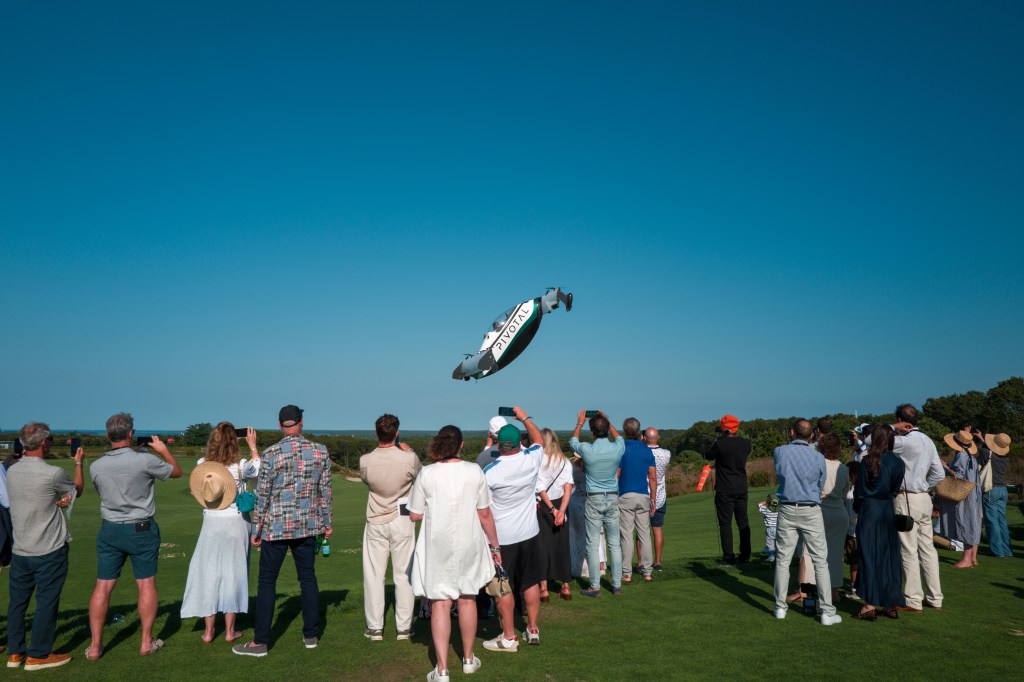 A crowd watching a hovering car at The Bridge IX.