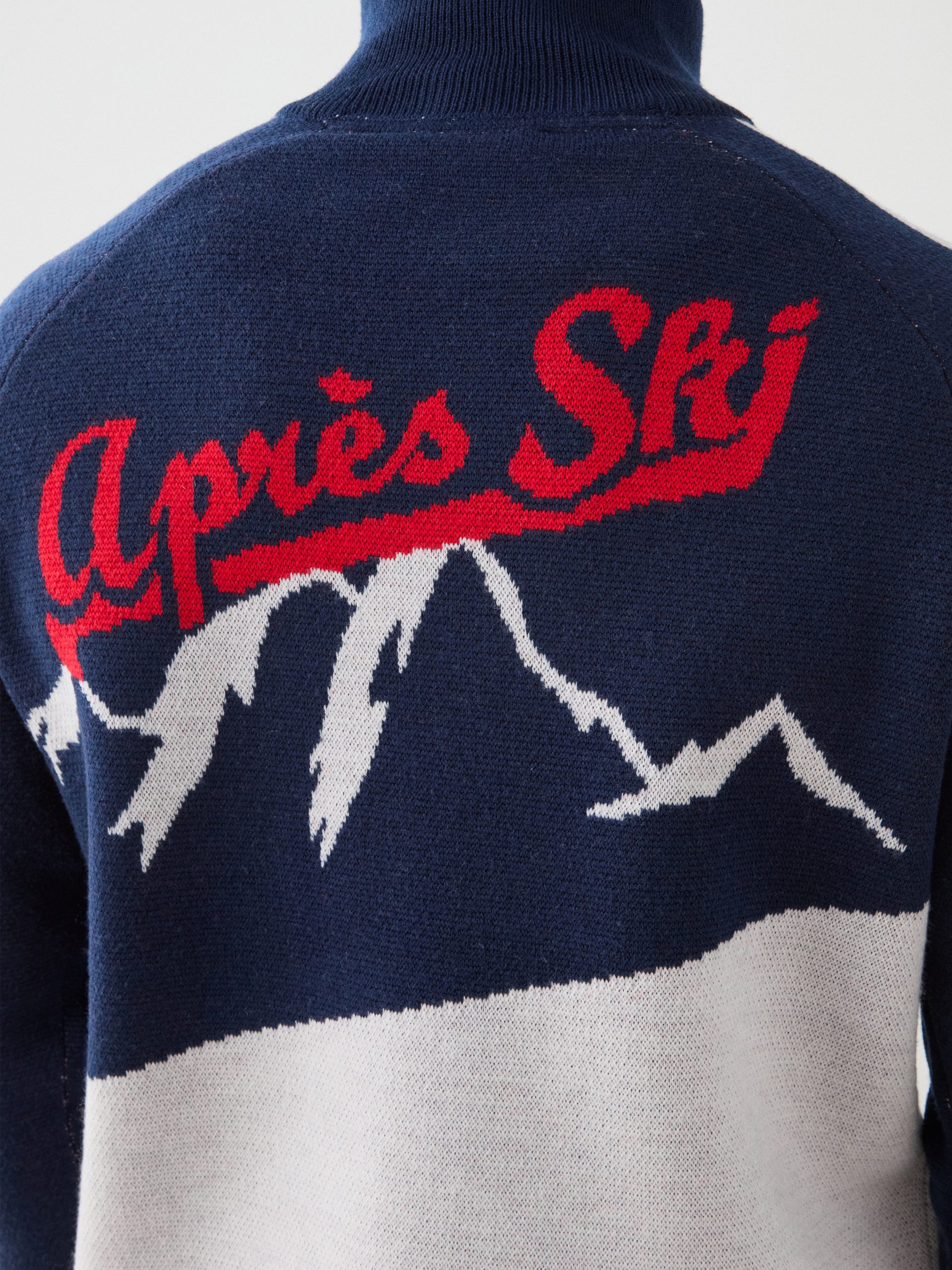 The back view of a sweater that says "Apres Ski."