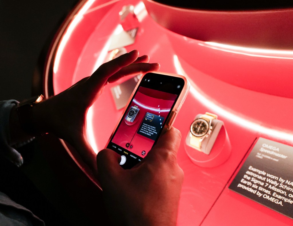 A detail of someone taking a photo of a watch at the Icons of Time exhibition.