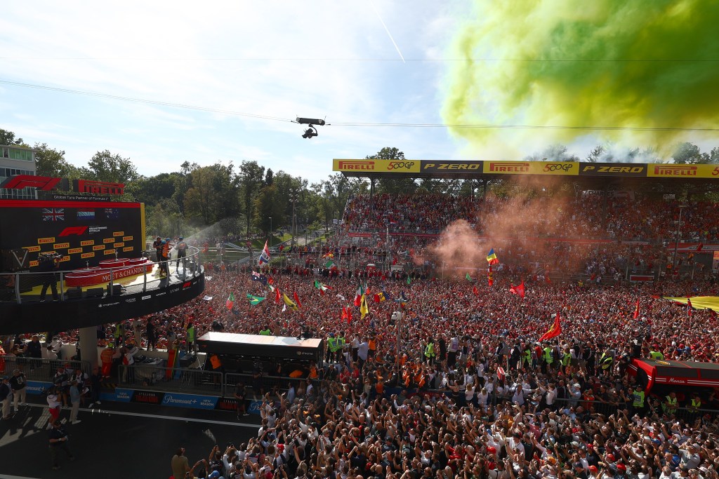 Race winner Max Verstappen spraying Moet from the elevated winner's podium onto the crowd below.