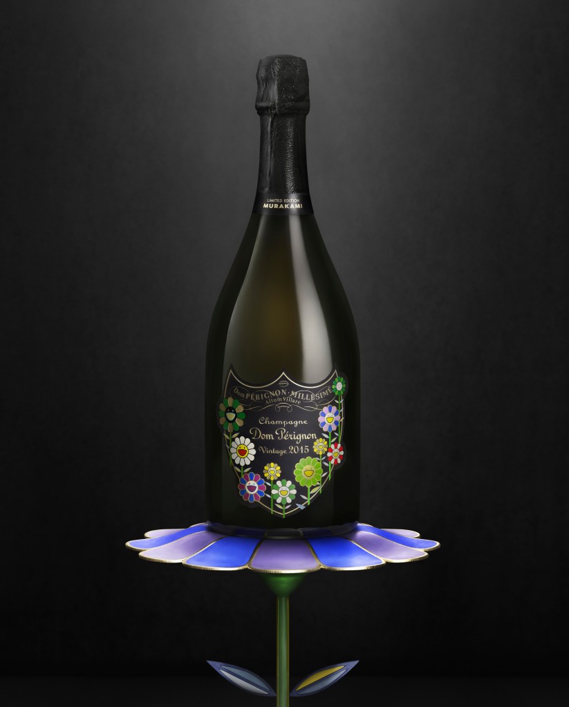 A bottle of Dom Pérignon Vintage 2015 sits atop a blue flower table.