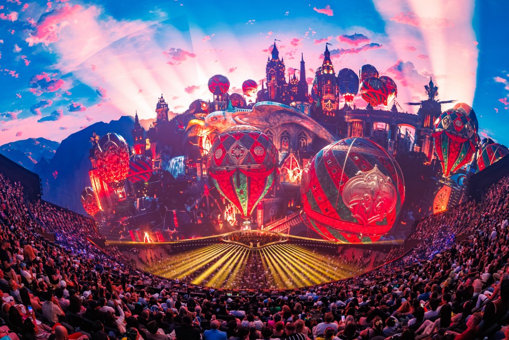 A photo of the Unity show at Sphere Las Vegas—with bright castles and balloons in deep colors, and the audience can be seen