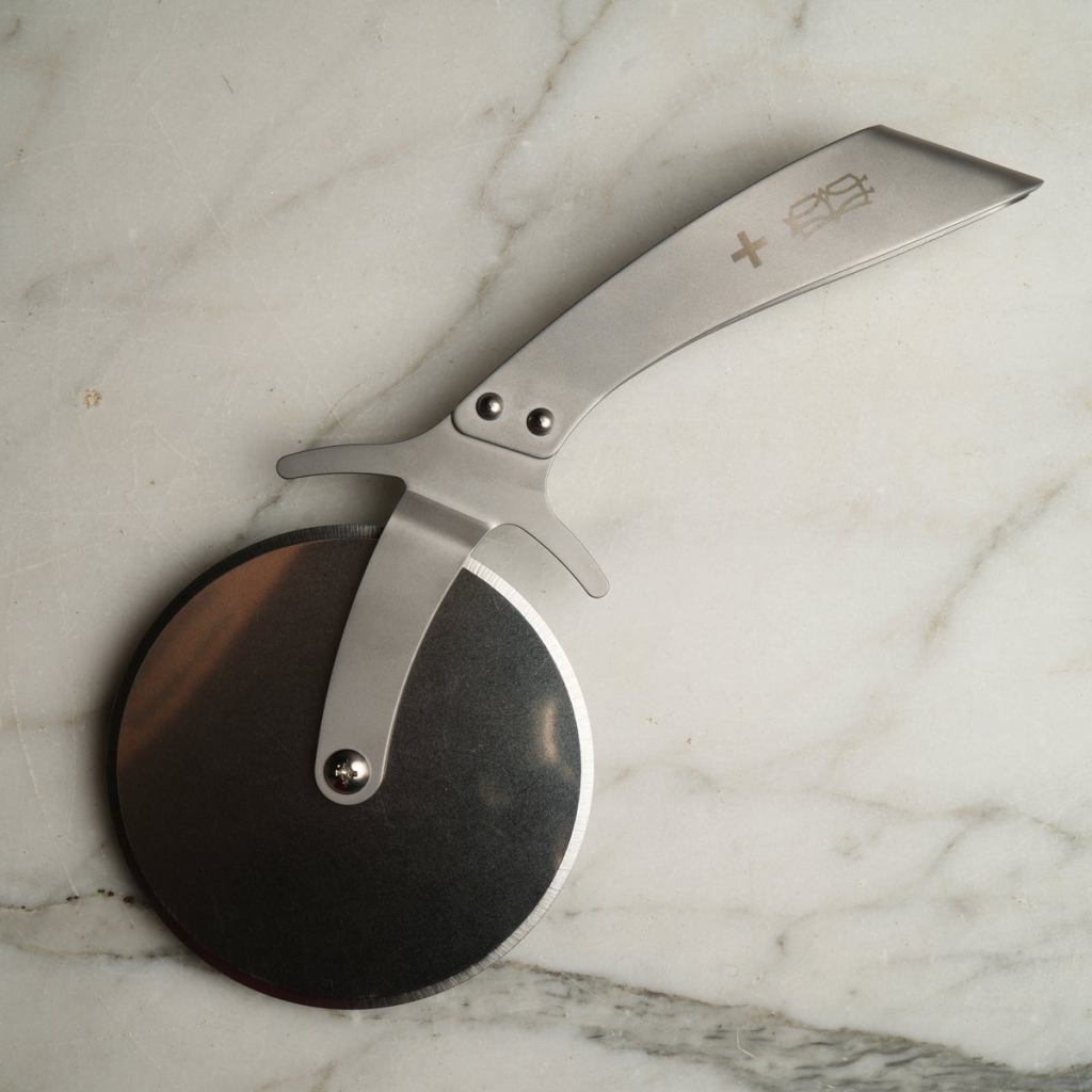 Bernal Cutlery's Prince stainless steel pizza cutter rests on a stone background