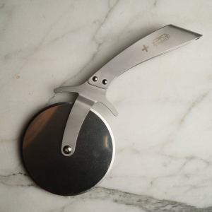 Bernal Cutlery's Prince stainless steel pizza cutter rests on a stone background