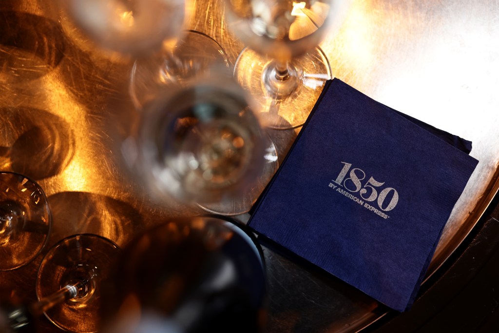 Cocktail glasses and an 1850 napkin shot overhead at the private cocktail party hosted by  Amex and Aaron Paul in Las Vegas.