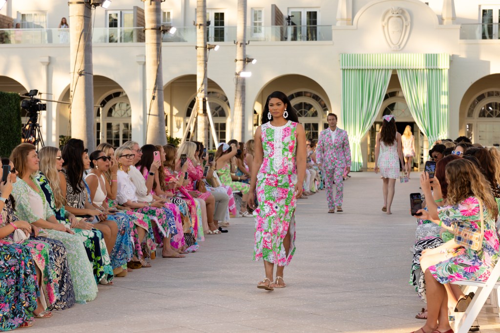 Chanel Iman walking down the runway of the Spring 2026 Lilly Pulitzer show wearing a long floral sleeveless dress.
