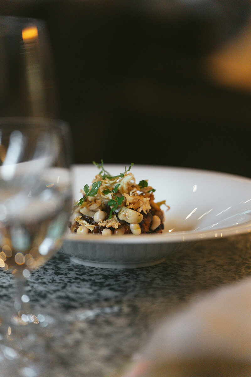 A detail of a plated dish of food and wine at The Omnia.