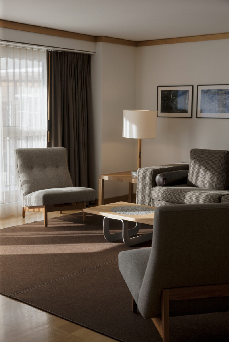 A guest room with couches and soft lighting at The Omnia.
