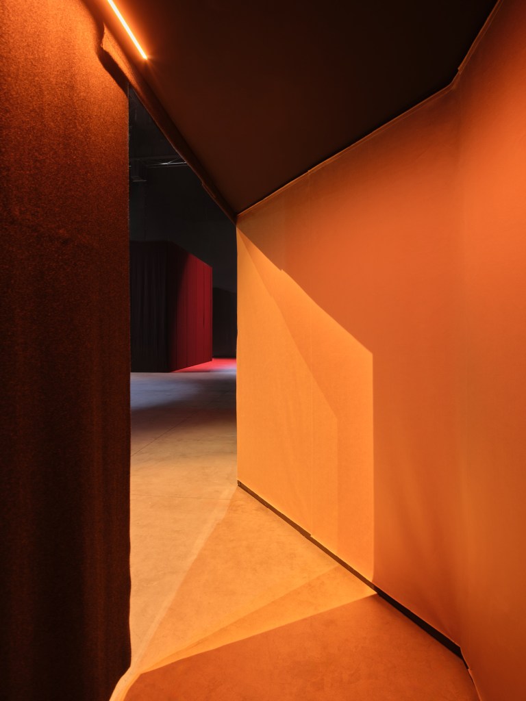 The corner of an orange hallway in Nan Goldin's exhibition at Pirelli HangarBicocca.