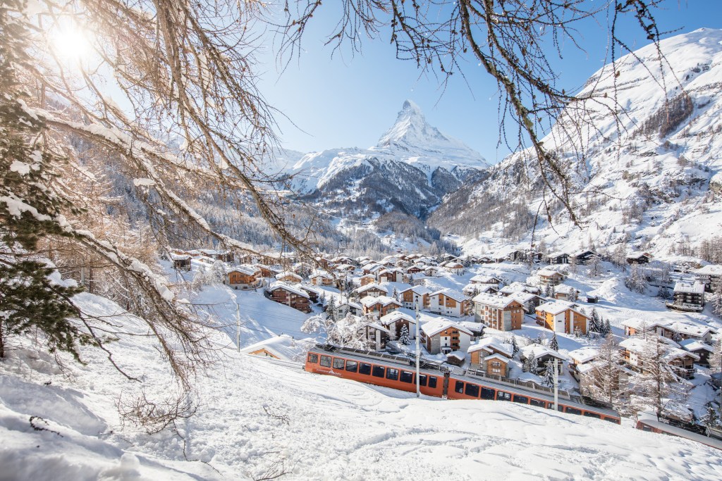 A snowy mountain scene with a Swiss village in the background.