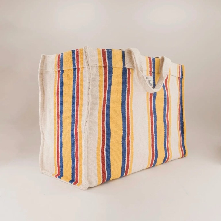 Moismont's hand woven cotton tote is featured in yellow, blue and red stripes on a plain background