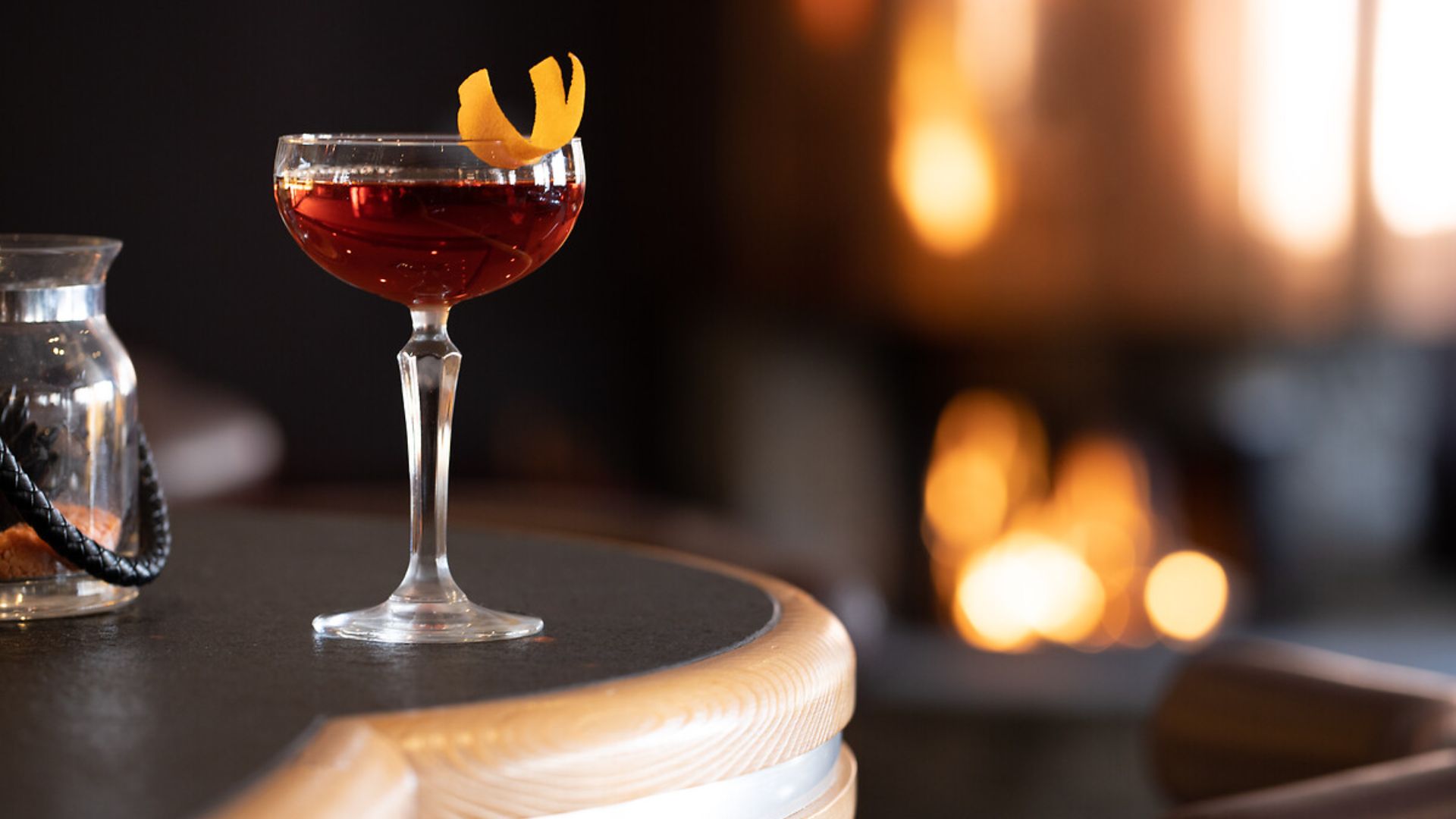 A cocktail with a fire in the background at Grill Le Cervin.