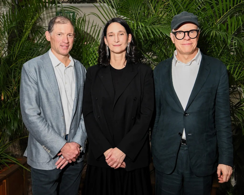 Glenn Fuhrman, Bettina Korek, Hans Ulrich Obrist standing in front of a green palm leaf wall.