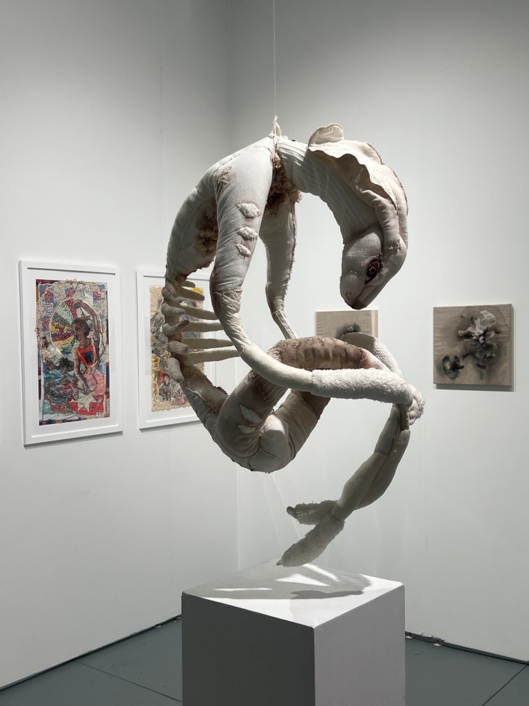 Hou Guan Ting's textile sculpture of an animal's body curving into a question mark shape.