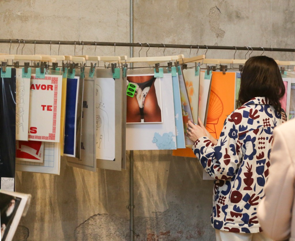 A vistor perusing hanging art prints at the ACME shop.