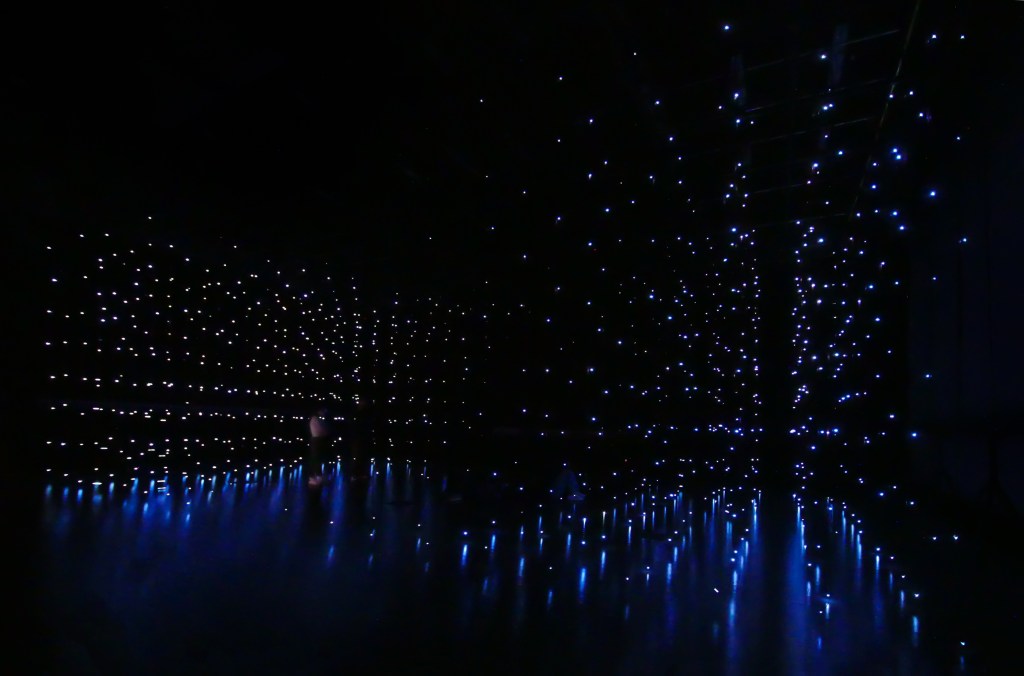 Andrew Schneider's NOWISWHENWEARE (the stars) Open Universe with colored lights and a dark background.