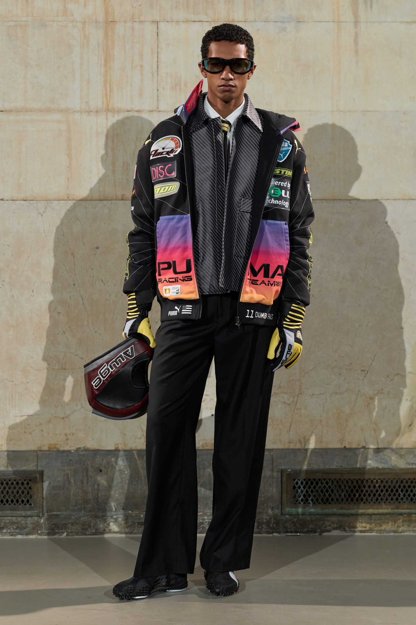 A male model wearing a colorful racing jacket look from AWGE's Fall Winter 2026 runway show.