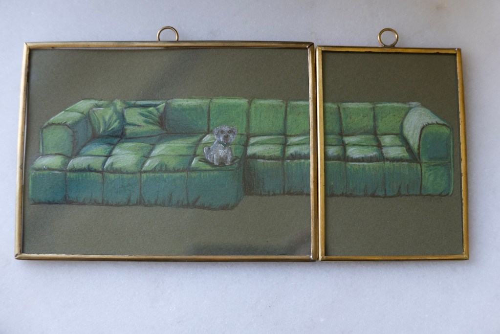 A small framed painting of a dog on a sofa by Andrea Pazos.