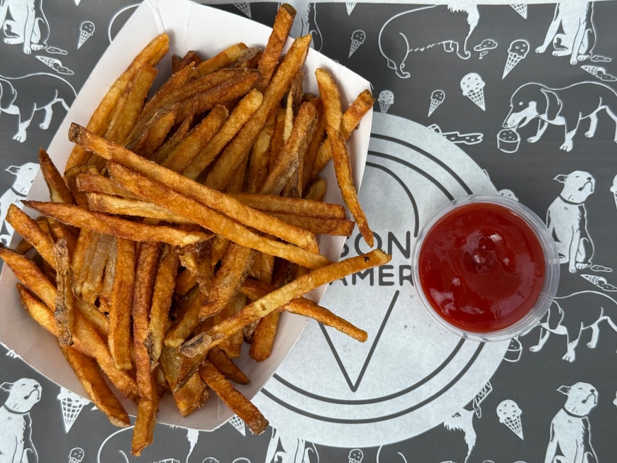 An overhead view of a  carton of fries and ketchup.