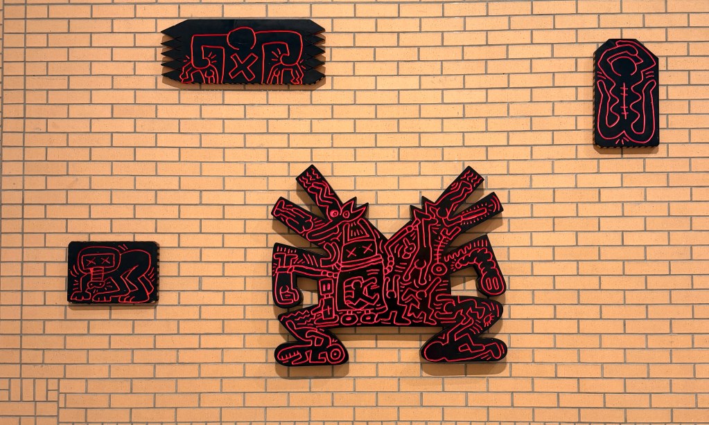 Several works in wood by Keith Haring in black and red
