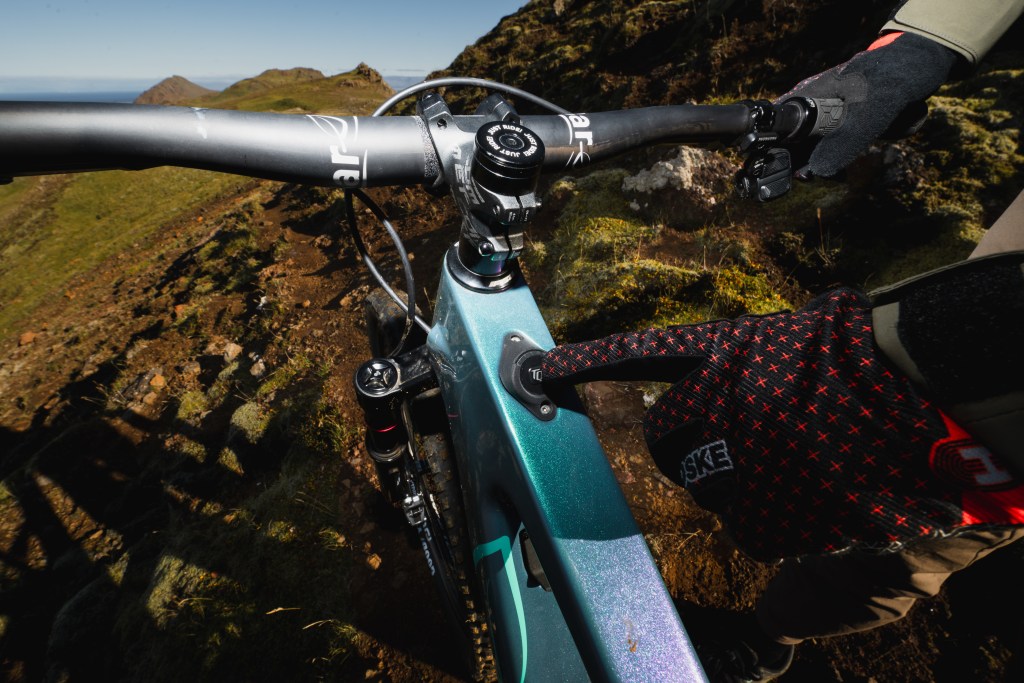 A gloved hand touching the minimal electric interface of the Lauf eElja bike.