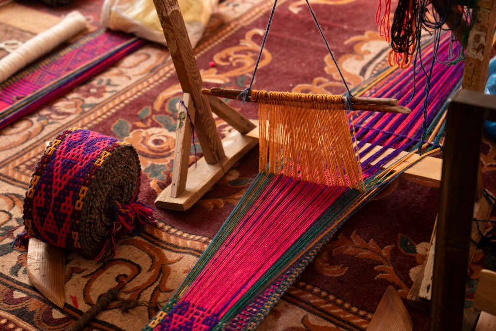 Uzbek hand weaving mat workshop in Nukus shows materials and a loom on a rug