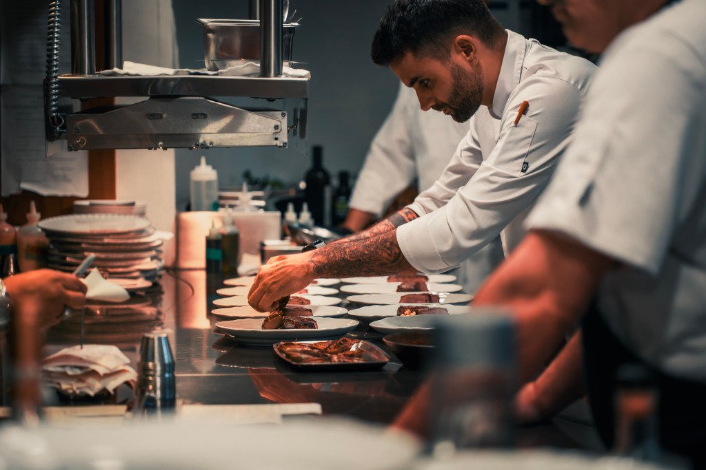 A chef prepares dishes on a counter